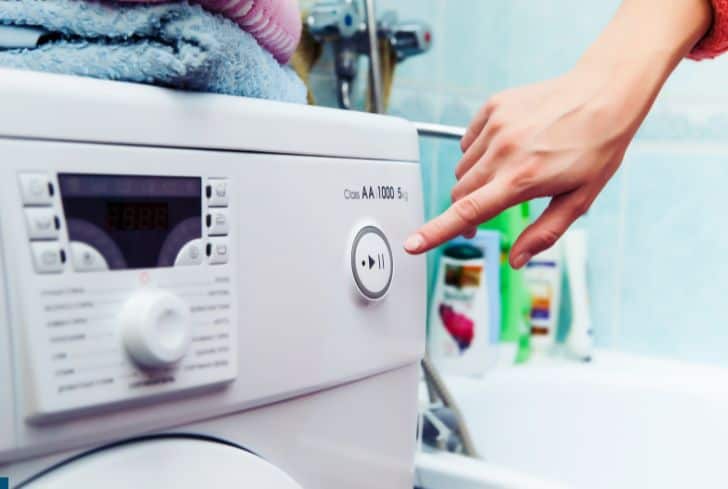 man-pressing-button-washing-machine